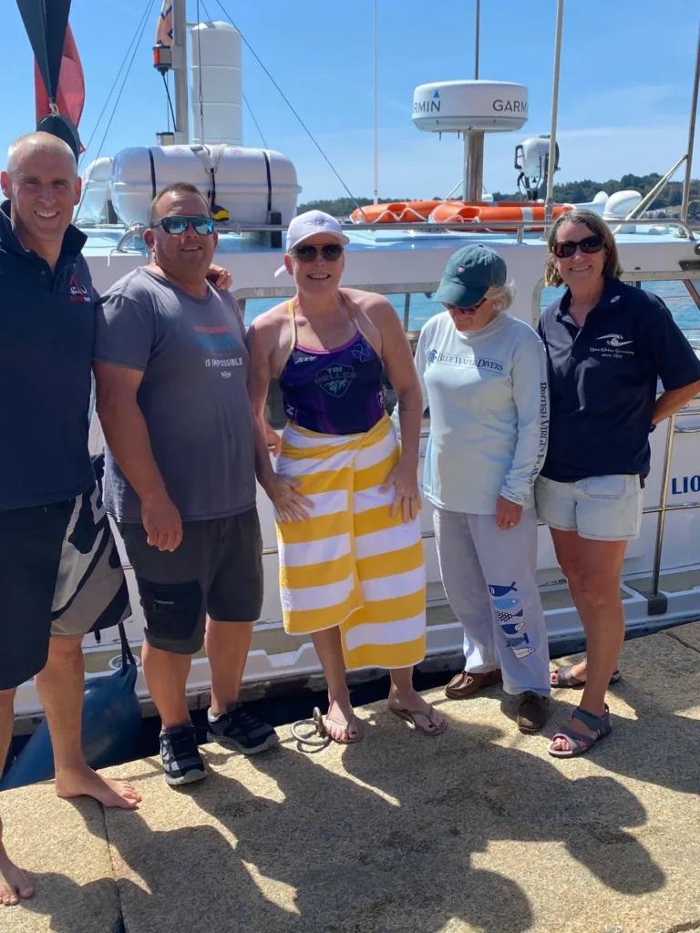 Jo Norman wrapped in a towel with her pilot crew and observers beside the Lionheart boat