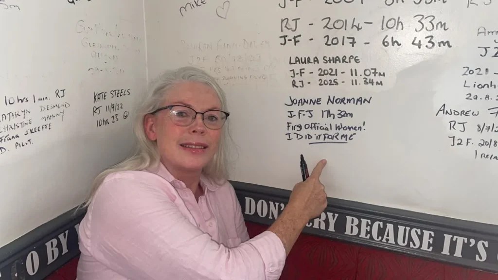 Jo Norman pointing to her entry on the swimmers wall: J-F-J 17h 32m, first official woman, I did it for me