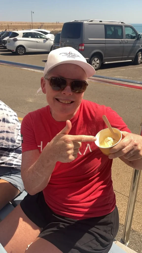Jo Norman pointing at a cup of ice cream by the harbour in Jersey