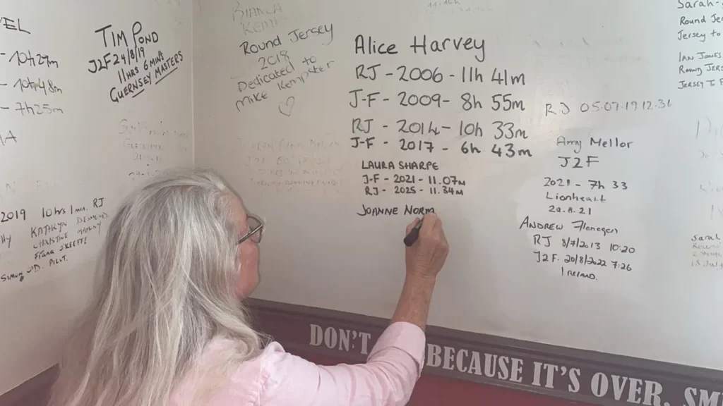 Jo Norman writing her name on the swimmers wall in Jersey